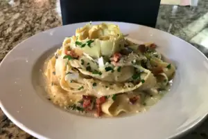 Homemade papardelle with artichoke hearts, pancetta, mushrooms and Parmigiano Romano.